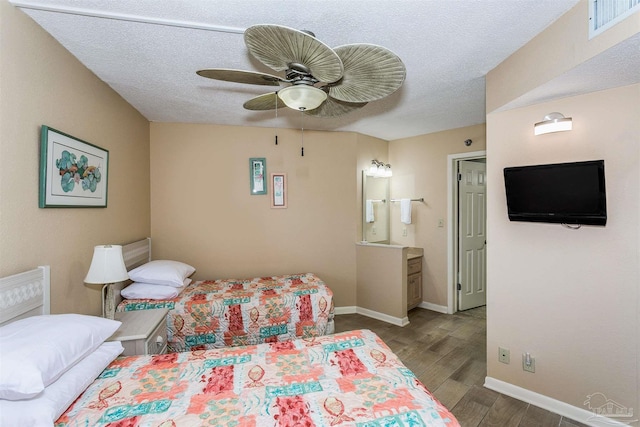 bedroom with a textured ceiling, visible vents, baseboards, wood finished floors, and a ceiling fan