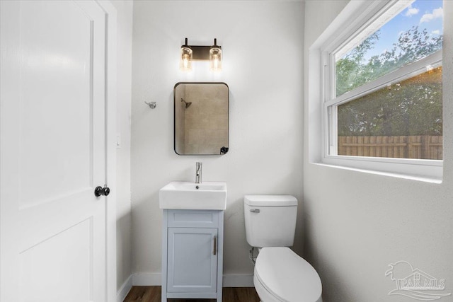 bathroom featuring wood-type flooring, vanity, and toilet