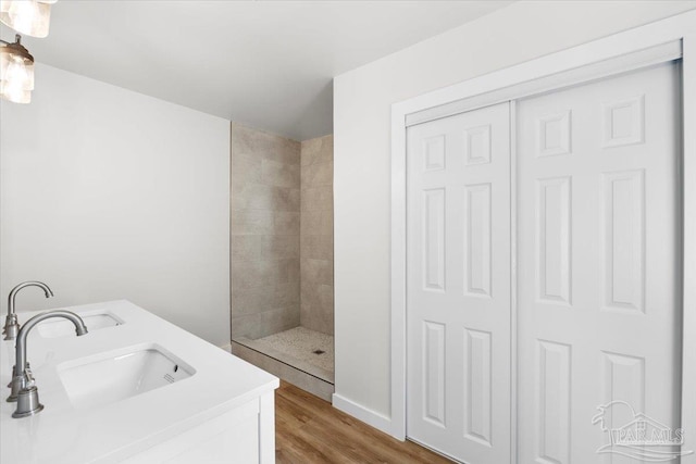 bathroom featuring tiled shower, vanity, and hardwood / wood-style flooring