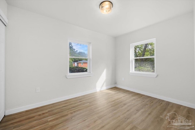 empty room featuring wood-type flooring and a healthy amount of sunlight