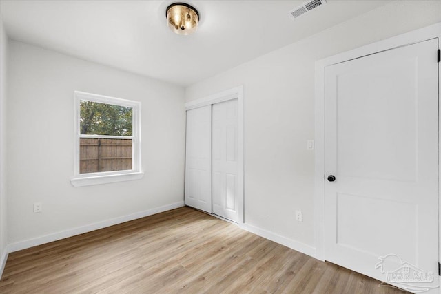 unfurnished bedroom featuring light hardwood / wood-style floors and a closet