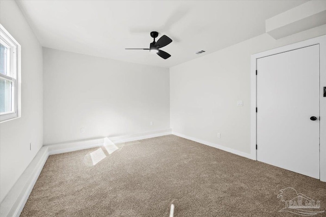 carpeted spare room with ceiling fan