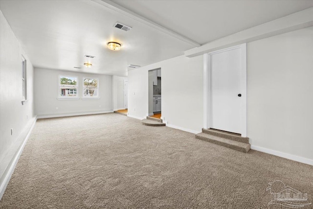 unfurnished living room featuring beamed ceiling and carpet floors