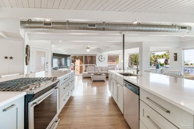 kitchen with visible vents, beam ceiling, a ceiling fan, appliances with stainless steel finishes, and light countertops