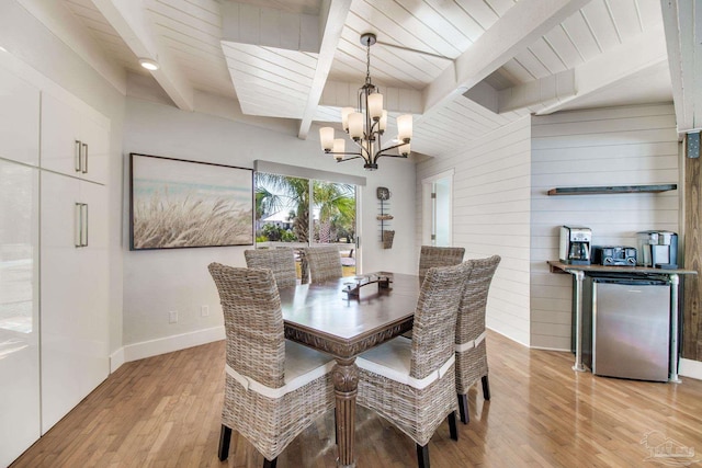 dining area featuring baseboards, a chandelier, beamed ceiling, wood ceiling, and light wood-style flooring