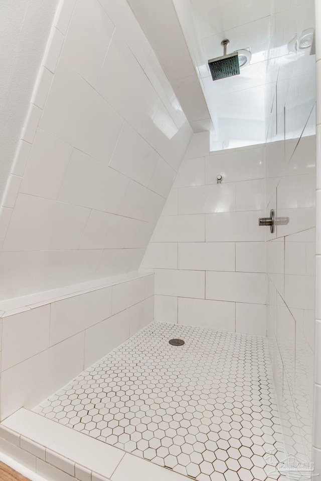 bathroom featuring tiled shower and vaulted ceiling