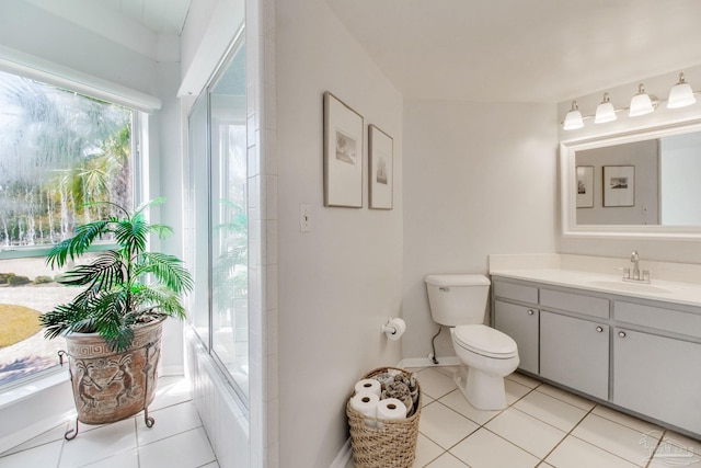 bathroom with tile patterned flooring, toilet, vanity, and baseboards