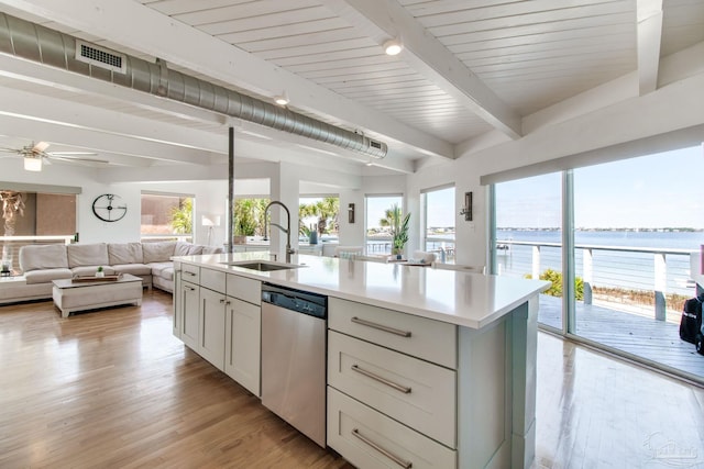 kitchen featuring visible vents, beamed ceiling, dishwasher, light countertops, and a sink