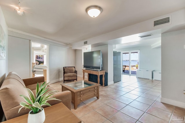 living room with light tile patterned floors, visible vents, and baseboards