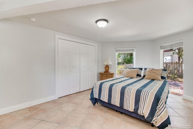 bedroom with light tile patterned floors, baseboards, and a closet