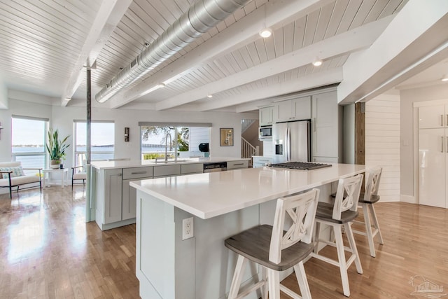 kitchen featuring a sink, stainless steel appliances, a large island, and gray cabinets