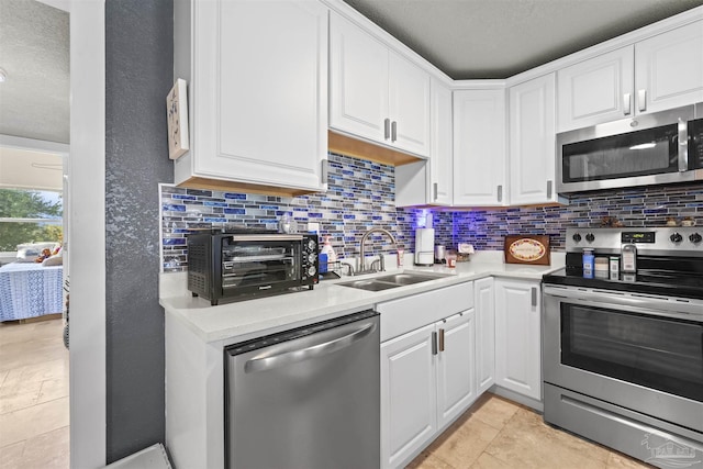 5607 Fairview Dr, Pensacola, FL 32505 - kitchen with stainless steel appliances, a sink, backsplash, light countertops, and a textured ceiling