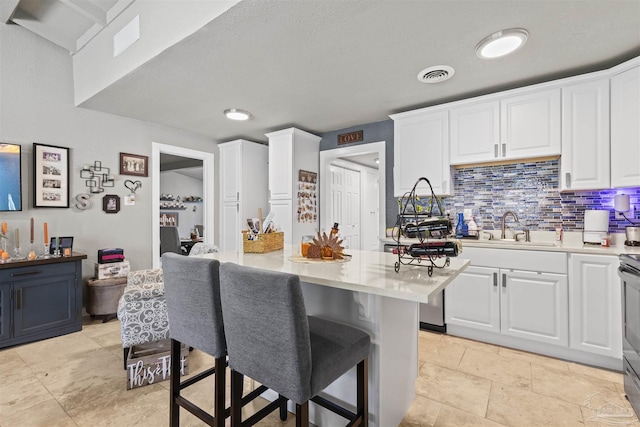 5607 Fairview Dr, Pensacola, FL 32505 - kitchen with a sink, white cabinetry, light countertops, and a kitchen breakfast bar