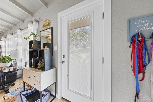 5607 Fairview Dr, Pensacola, FL 32505 - doorway featuring beamed ceiling and a textured wall