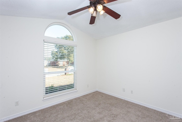 carpeted empty room with ceiling fan and lofted ceiling