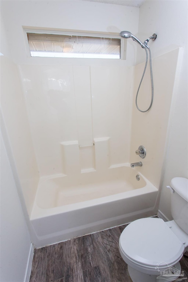 bathroom with hardwood / wood-style floors,  shower combination, toilet, and a healthy amount of sunlight