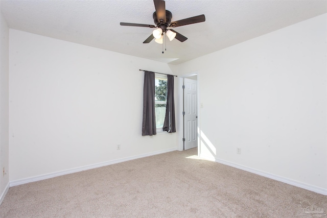 carpeted empty room with ceiling fan and a textured ceiling