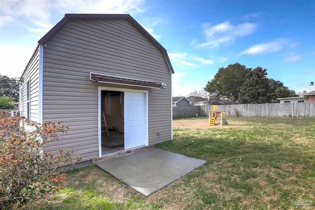 back of house featuring a playground, an outdoor structure, and a yard