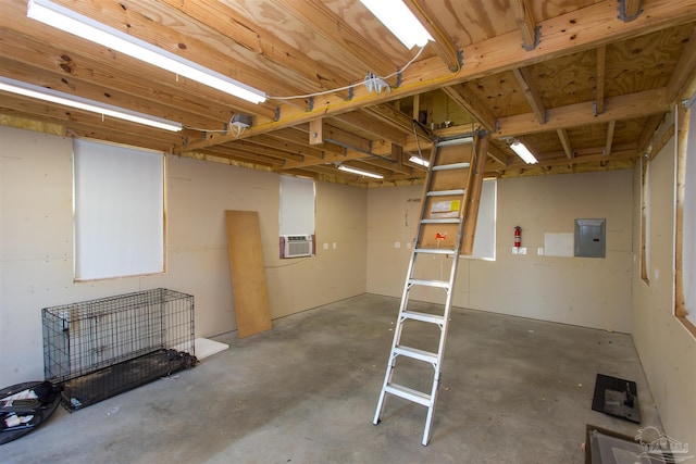 basement featuring electric panel and a wall unit AC