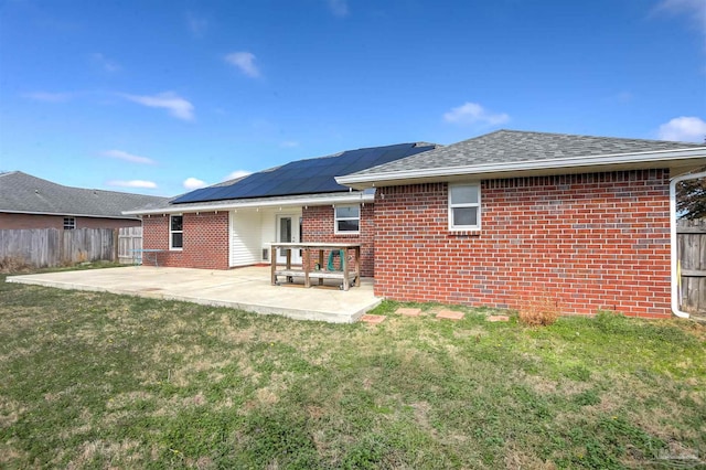 back of house featuring solar panels, a lawn, and a patio area