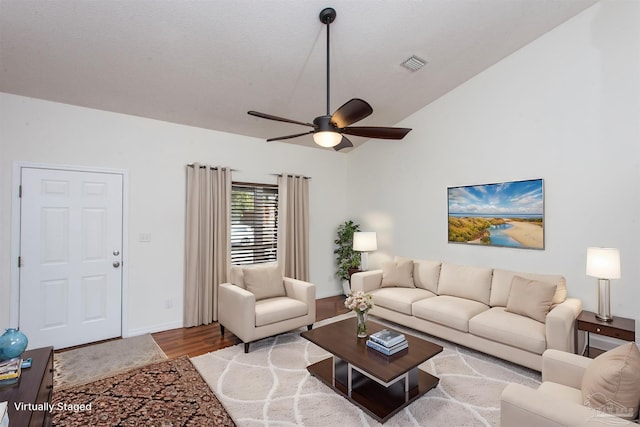 living room with lofted ceiling, ceiling fan, and light hardwood / wood-style flooring