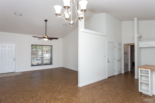 interior space with dark tile patterned flooring, ceiling fan with notable chandelier, and high vaulted ceiling