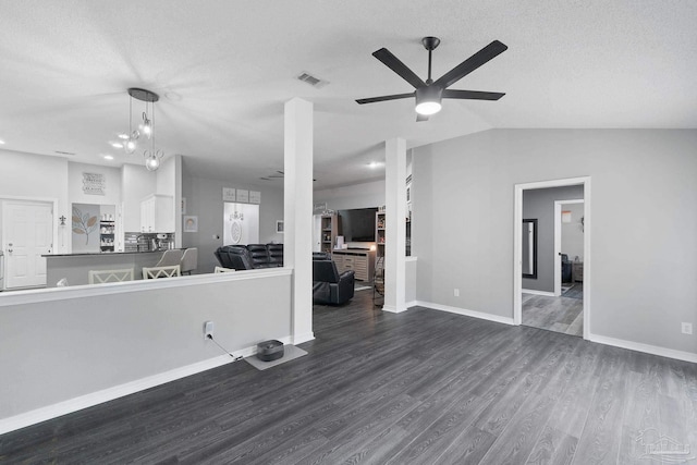 unfurnished living room featuring ceiling fan, lofted ceiling, dark hardwood / wood-style floors, and a textured ceiling