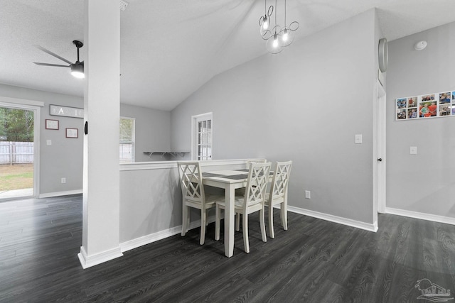 dining space with vaulted ceiling, ceiling fan with notable chandelier, and dark hardwood / wood-style flooring