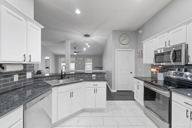 kitchen with hanging light fixtures, white cabinetry, appliances with stainless steel finishes, and sink