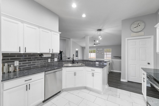 kitchen featuring sink, kitchen peninsula, white cabinets, and appliances with stainless steel finishes