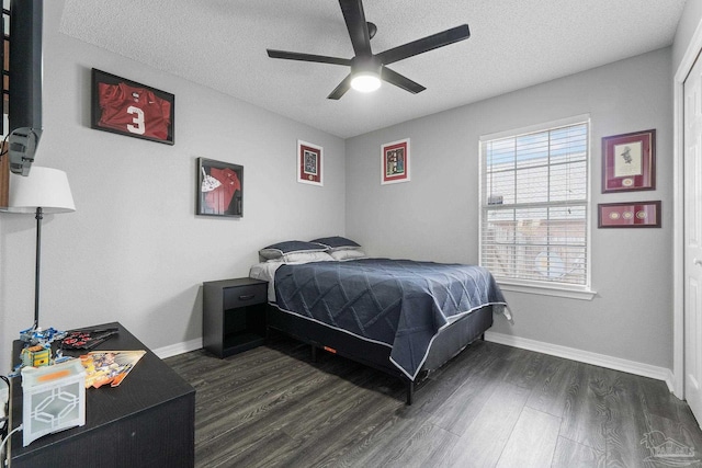 bedroom with ceiling fan, dark hardwood / wood-style flooring, and a textured ceiling