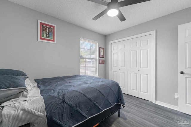 bedroom featuring ceiling fan, dark wood-type flooring, a textured ceiling, and a closet