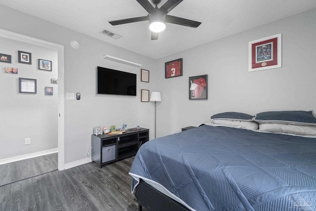 bedroom with dark hardwood / wood-style flooring, a textured ceiling, and ceiling fan