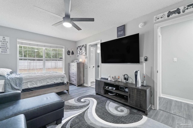 bedroom featuring wood-type flooring, ceiling fan, and a textured ceiling