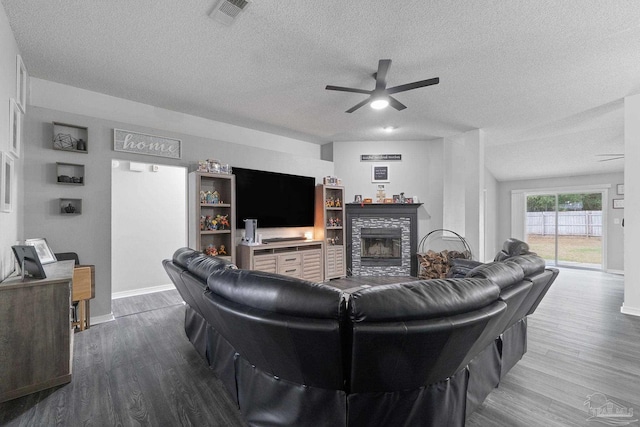 living room featuring hardwood / wood-style flooring, a textured ceiling, and ceiling fan