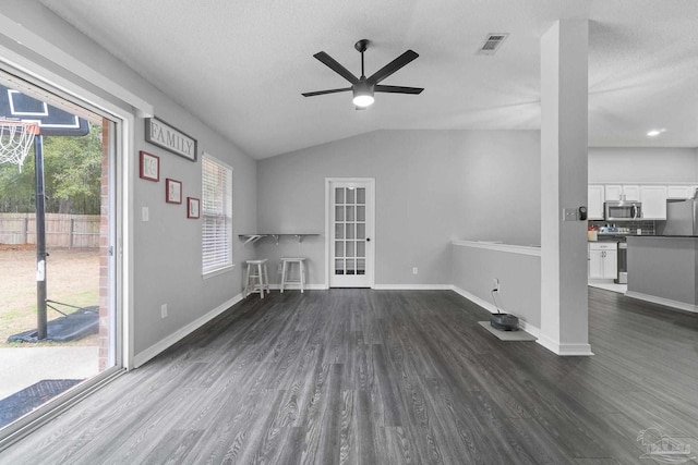 unfurnished living room featuring dark hardwood / wood-style flooring, a textured ceiling, lofted ceiling, and ceiling fan