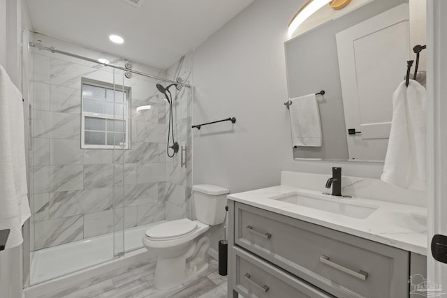 bathroom featuring vanity, hardwood / wood-style flooring, toilet, and a shower with door