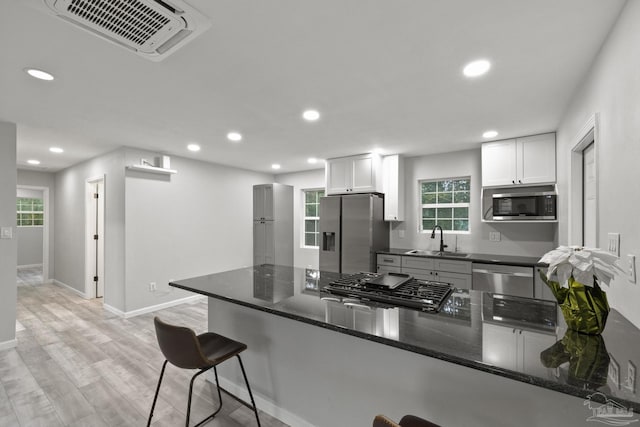 kitchen featuring white cabinetry, kitchen peninsula, and appliances with stainless steel finishes