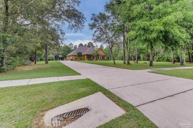 view of front facade with concrete driveway and a front yard