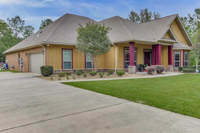 view of front of home with a porch, concrete driveway, a garage, board and batten siding, and a front yard