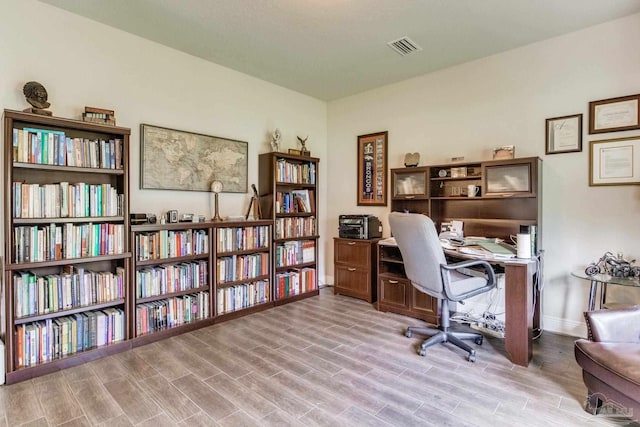 office with visible vents, baseboards, and wood finished floors
