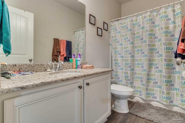 full bath featuring a shower with shower curtain, wood finished floors, toilet, and vanity