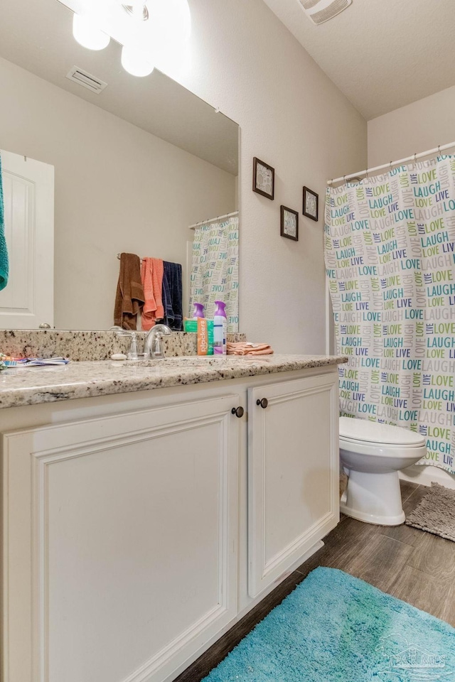 full bathroom with wood finished floors, visible vents, toilet, vanity, and a shower with curtain