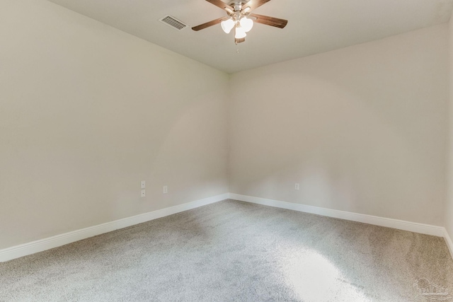 carpeted empty room with baseboards, a ceiling fan, and visible vents