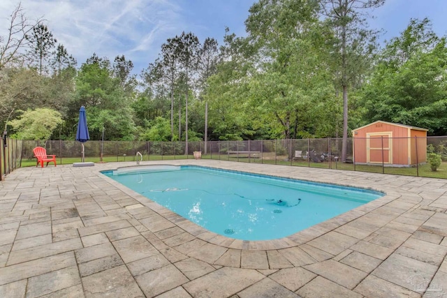 view of pool with fence, a patio area, a fenced in pool, and a storage unit