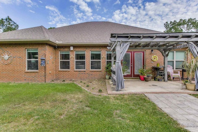 rear view of house with a shingled roof, a pergola, a lawn, and brick siding