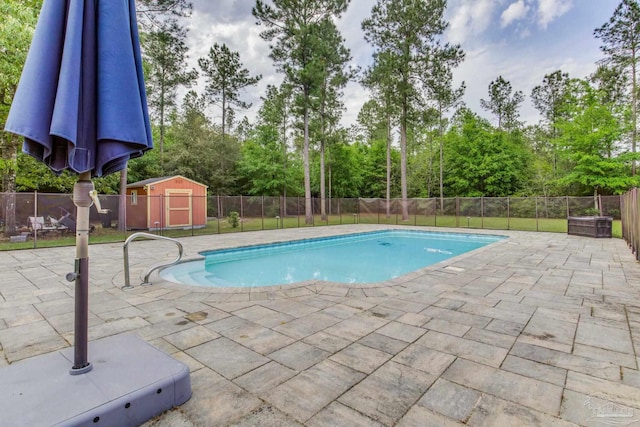 view of swimming pool with a patio area, a fenced backyard, a storage unit, and a fenced in pool