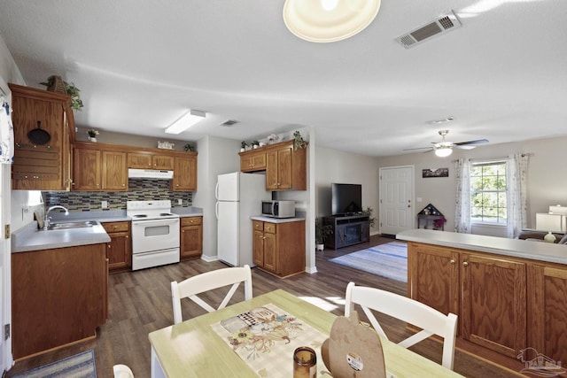 kitchen featuring decorative backsplash, dark hardwood / wood-style flooring, white appliances, ceiling fan, and sink