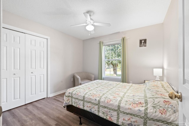 bedroom with a textured ceiling, a closet, hardwood / wood-style flooring, and ceiling fan