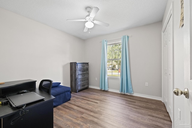 office with ceiling fan, dark wood-type flooring, and a textured ceiling